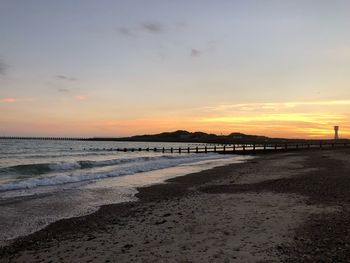 Scenic view of beach against sky during sunset