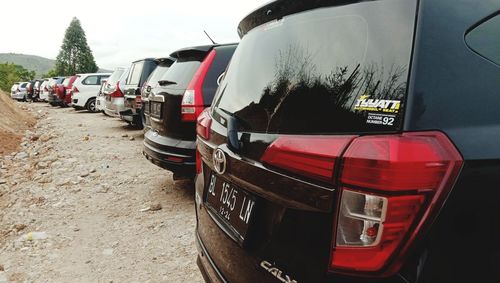 Vehicles on road against sky in city