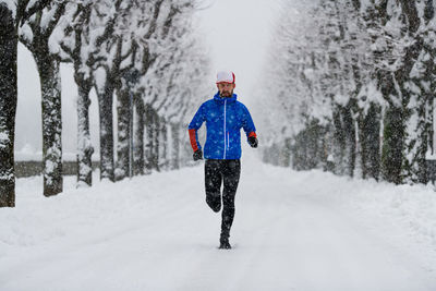 Rear view of man standing on snow covered land