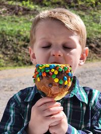 Close-up of boy eating carmel apple