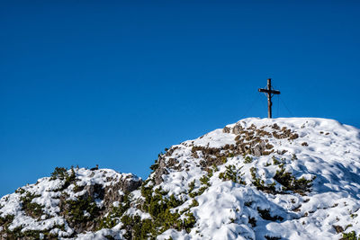 Low angle view of snowcapped mountain against blue sky