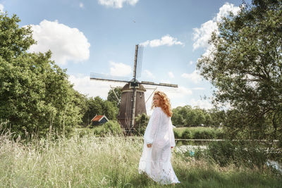 Rear view of woman standing on field