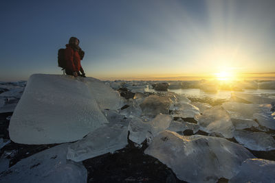 Scenic view of frozen lake against sky during sunset