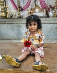 Portrait of cute girl sitting on floor