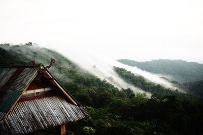 Scenic view of house and mountains against sky