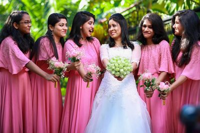 Bride standing with bridesmaids against trees