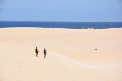 People on beach against sky