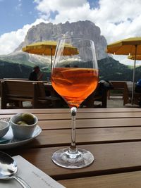 Close-up of wineglass on table against sky