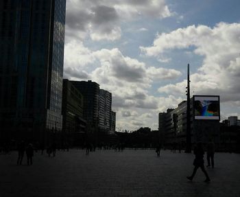 Modern buildings in city against cloudy sky