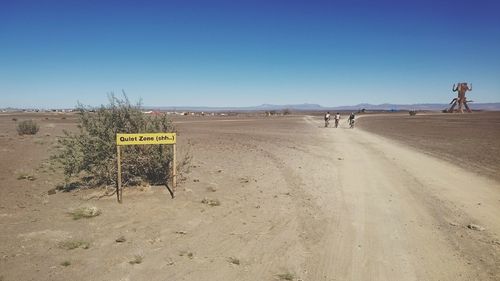 Scenic view of desert against clear blue sky