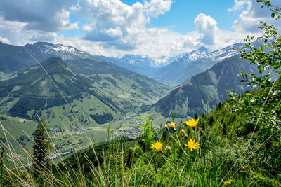 Scenic view of grassy field and mountains against sky