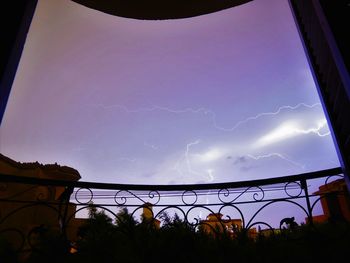 Panoramic view of illuminated ferris wheel against sky at night