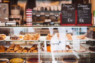 Various pastry items arranged in window cabinet at bakery shop