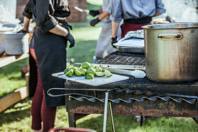 Low section of men working on barbecue grill