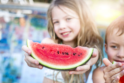 Cute siblings having watermelon outdoors