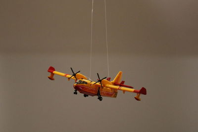 Toy airplane hanging against gray background