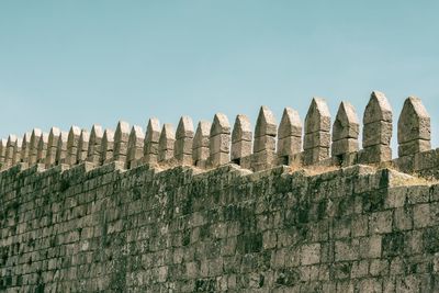 Low angle view of tall wall against clear sky