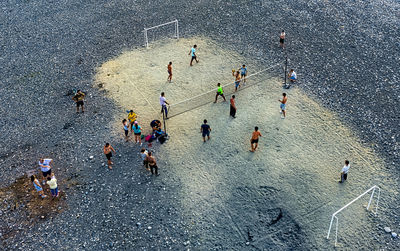 Drone view of people playing soccer at beach