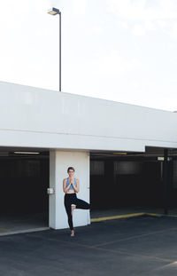 Full length of woman standing against building