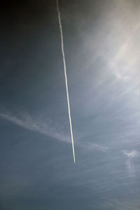 Low angle view of vapor trail against blue sky