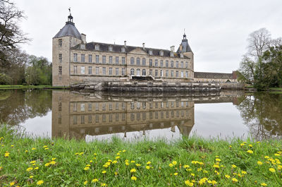 Reflection of building in lake against sky