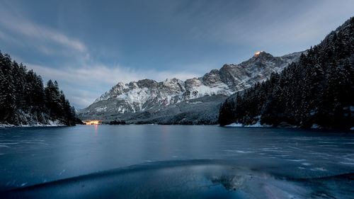 Scenic view of river by mountains against sky