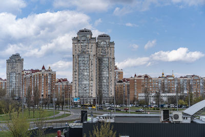 View of skyscrapers in city against cloudy sky