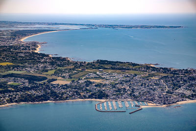 High angle view of cityscape by sea against sky