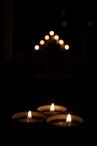 Close-up of lit candles in the dark