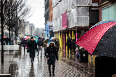 People walking on city street on rainy day