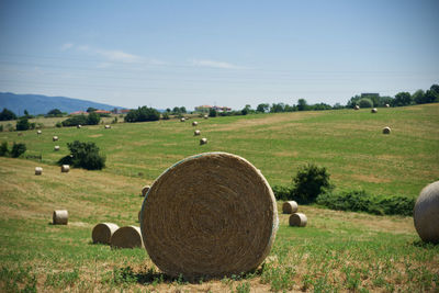 Hay bales on field against sky