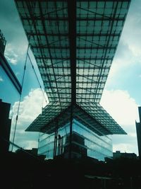 Low angle view of modern building against cloudy sky