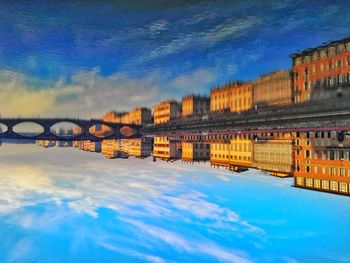 Reflection of buildings in sea against sky