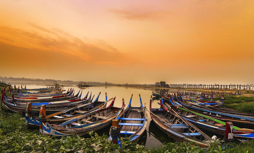 Panoramic view of boats moored in sea against sky during sunset