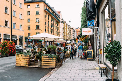 People on street amidst buildings in city