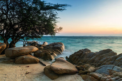 Seascape of motion wave through stone arch on beach at sunrise in ko man klang, rayong, thailand. 