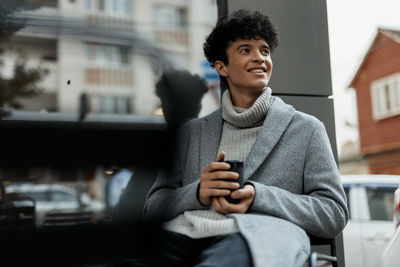 Young man using mobile phone while sitting in cafe