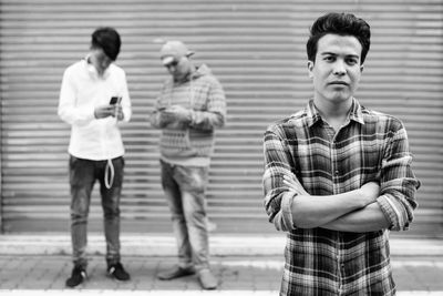 Portrait of smiling man with people using mobile in background