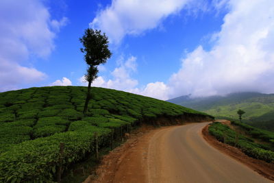 Country road against cloudy sky