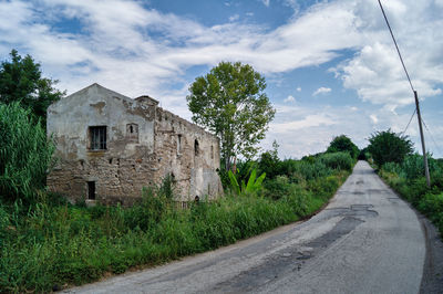 Road amidst old buildings against sky