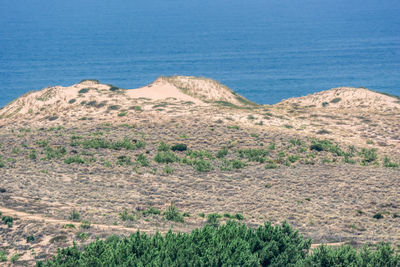 Scenic view of sea and mountains against blue sky