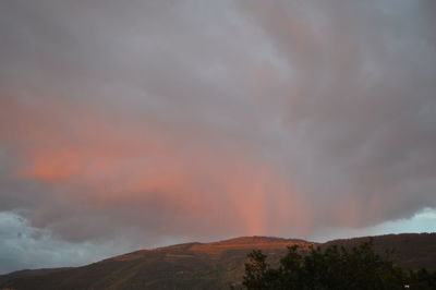 Scenic view of rainbow over mountains against sky