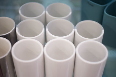A few white glasses on the shelf. white cylinder tanks, top view