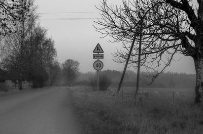 Road amidst trees and buildings against sky