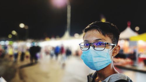 Portrait of young man wearing sunglasses while standing in city