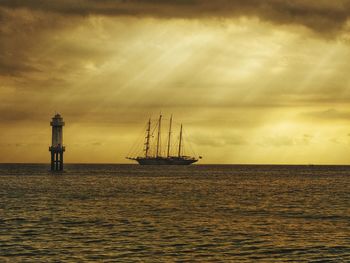 Boat in sea against sky during sunset