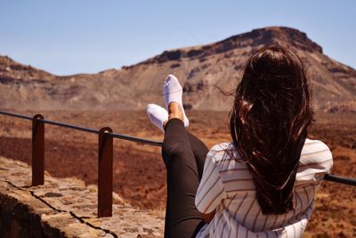 Rear view of woman on landscape against clear sky