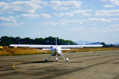 View of airplane at airport runway against sky