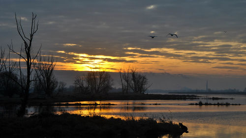 Scenic view of lake against sky during sunset