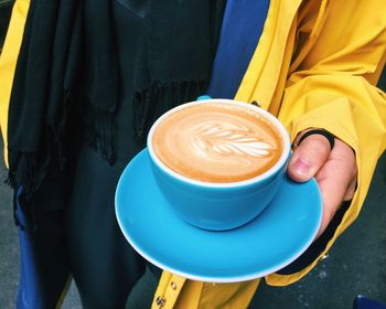 Midsection of man holding coffee cup